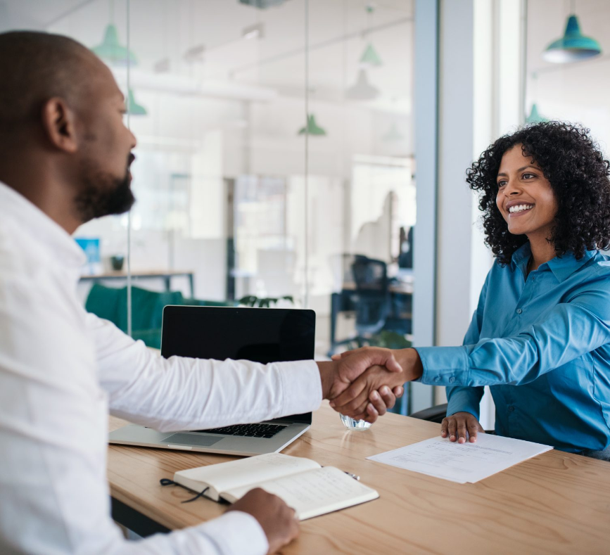 Two people shaking hands over a table